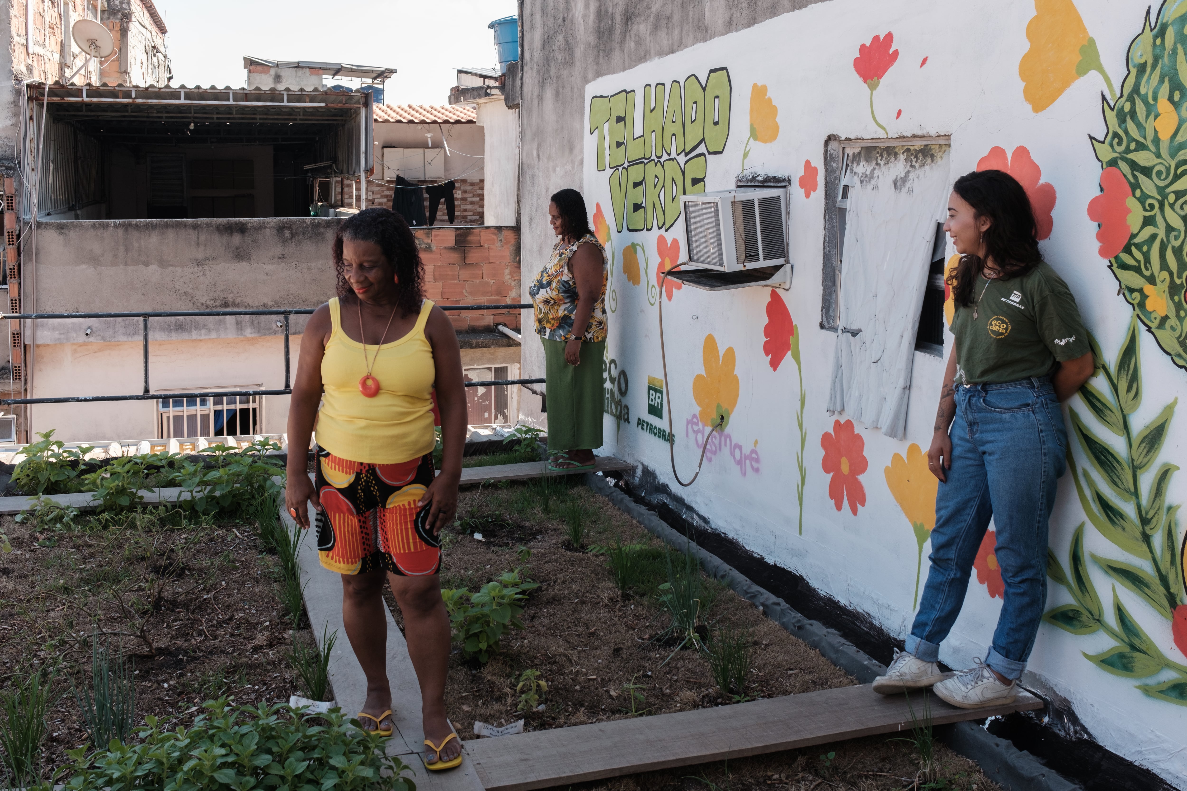 Soraia, Saionara and Vitória on the green roof of the Maré complex.