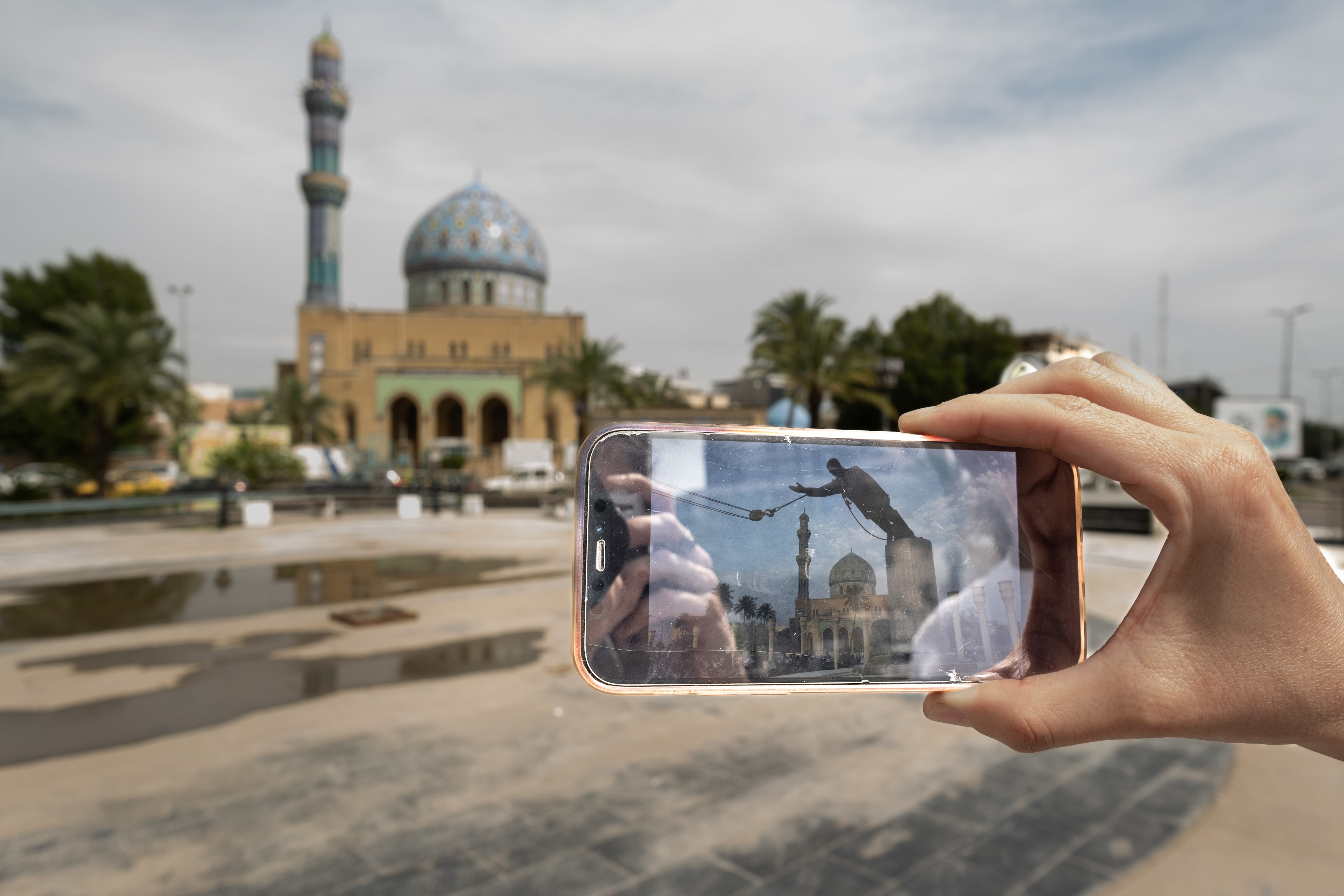 Firdos Square in central Baghdad with a 2003 cellphone photo of the same spot as the statue of Saddam Hussein was being toppled. 