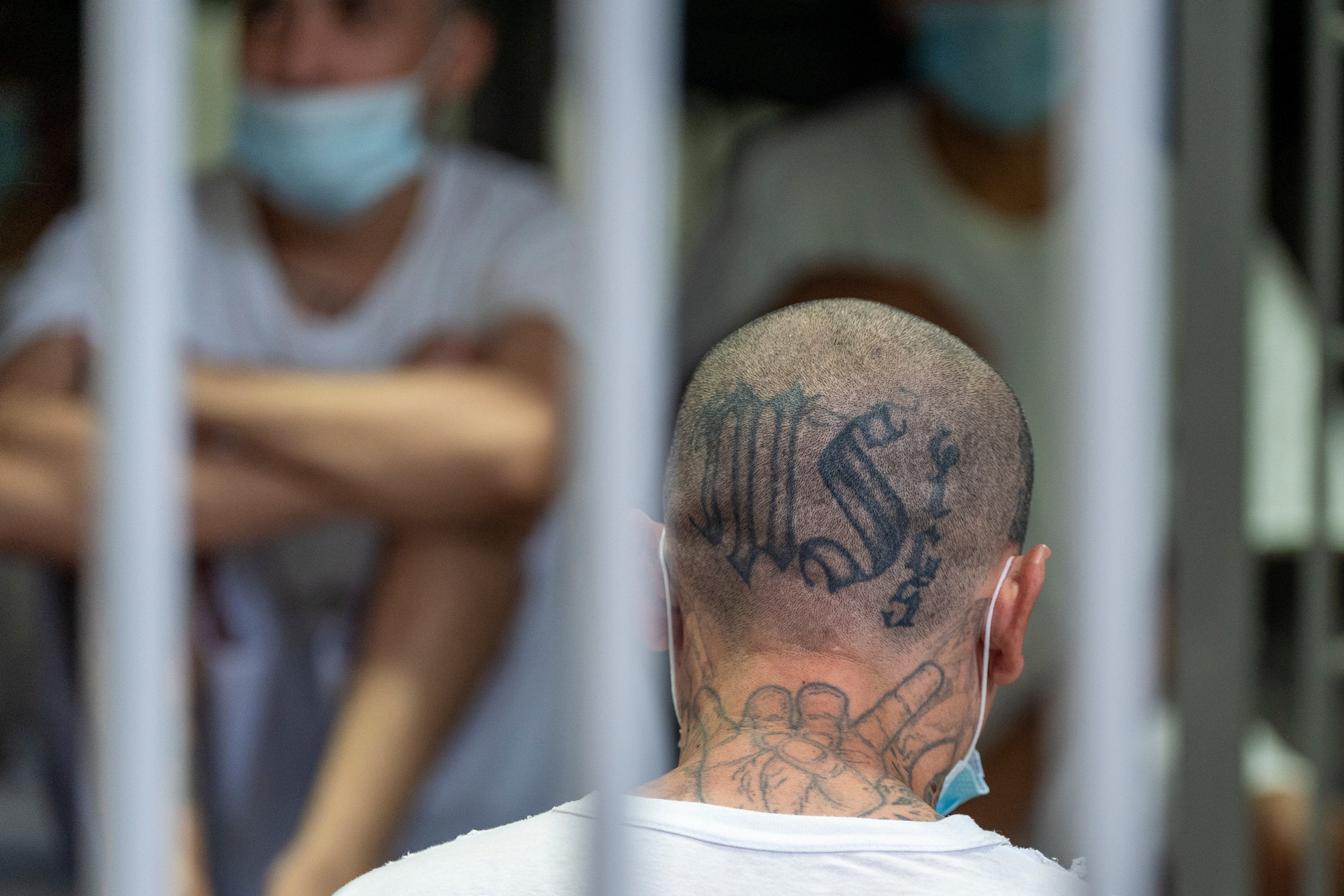 An inmate with MS-13 gang tattoos sits in his cell as Department of Homeland Security Secretary Kristi Noem tours the Terrorist Confinement Center.