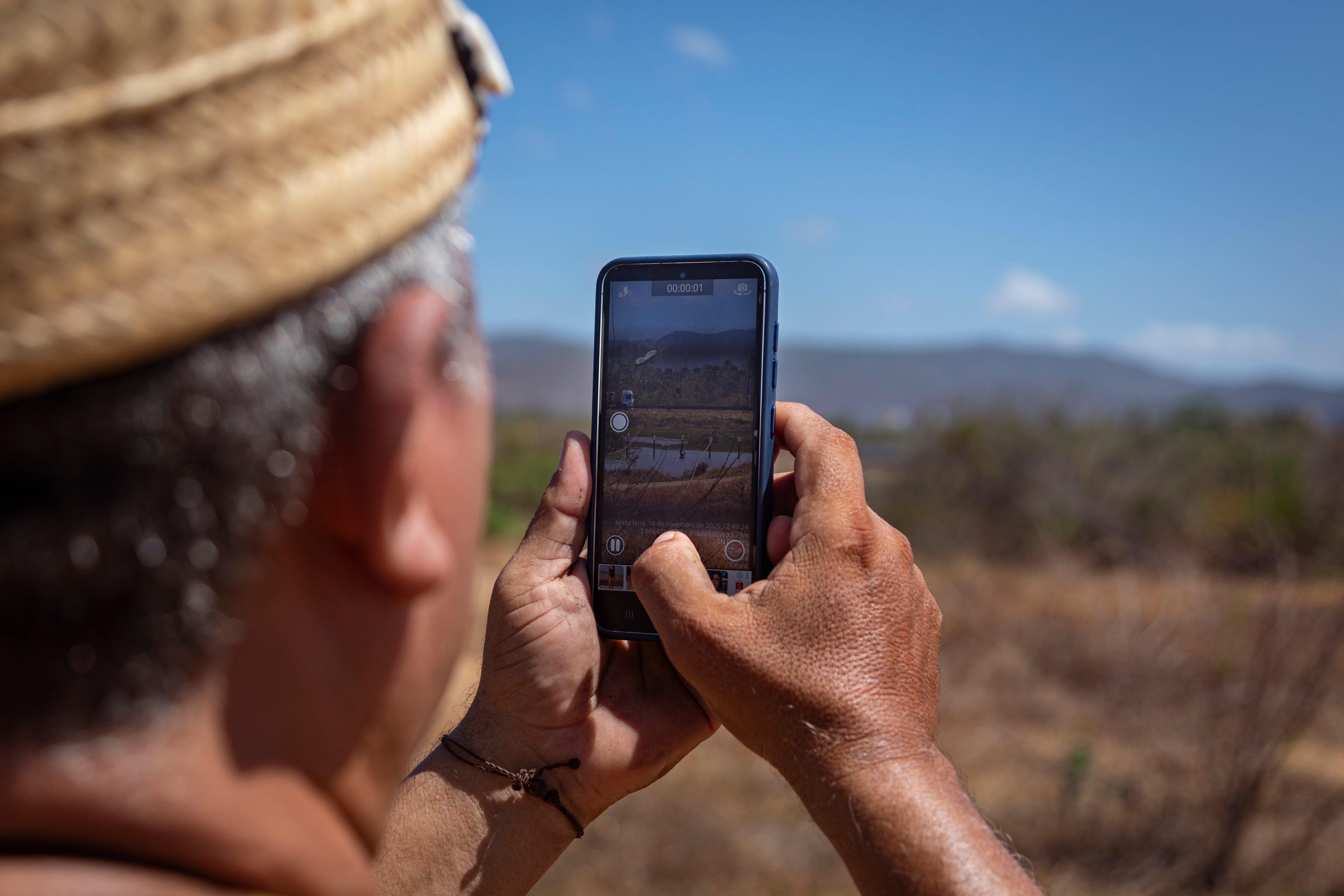 Chief Roberto, leader of the Anacé indigenous people, photographs the land where the TikTok data center is set to be built.