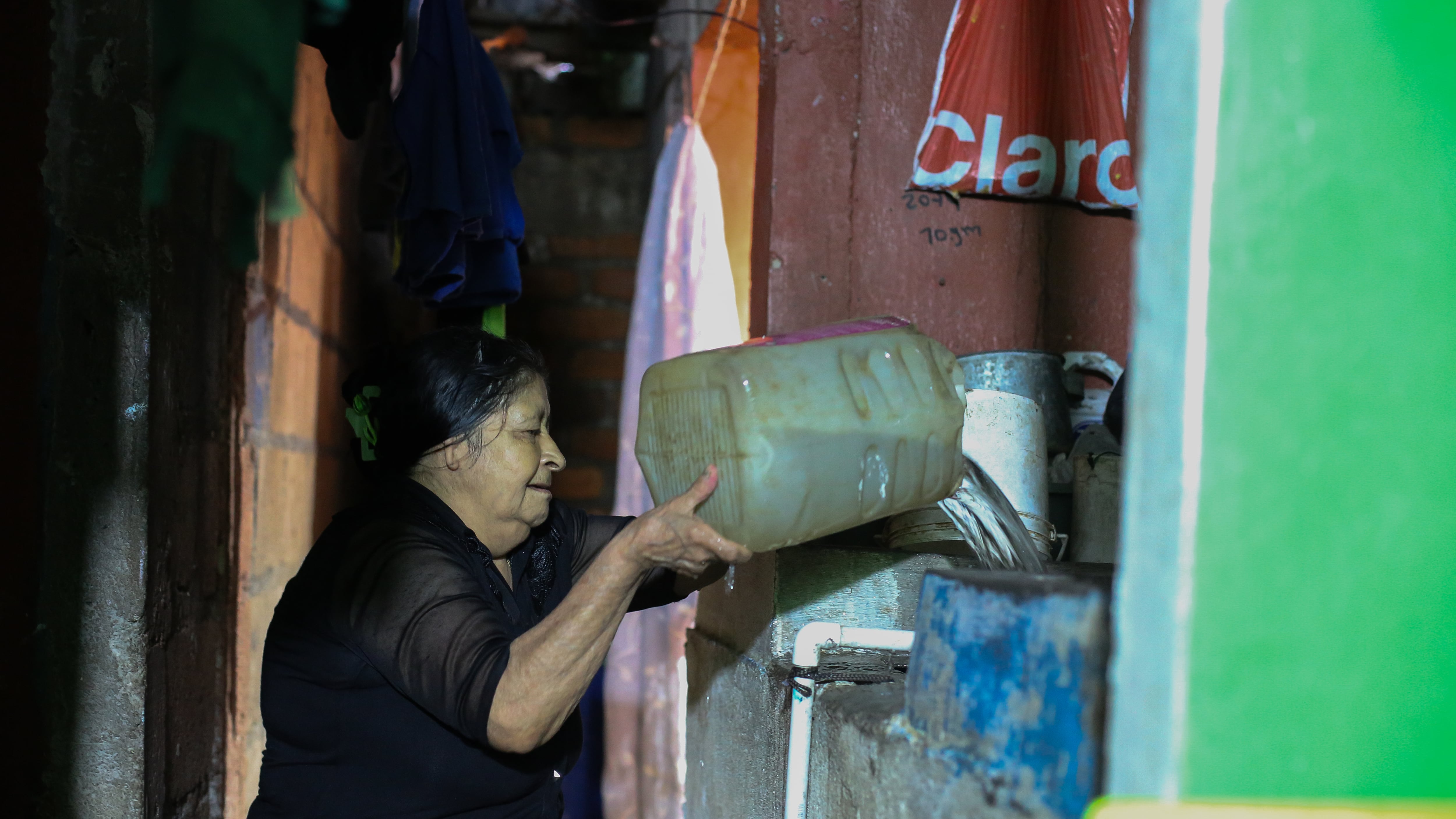 Suyapa Alvarenga pours rain-collected water from a barrel into her sink in Tegucigalpa on October 7.