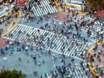 Pedestrians cross the Shibuya intersection in Tokyo, one of the busiest in the world.