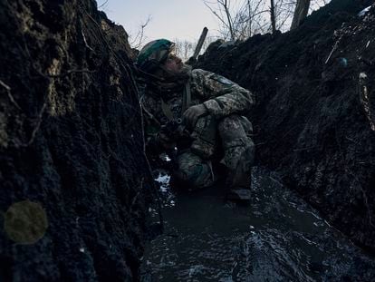 A Ukrainian soldier takes cover in a trench under Russian shelling on the frontline close to Bakhmut, Donetsk region, Ukraine, on Sunday, March 5, 2023.