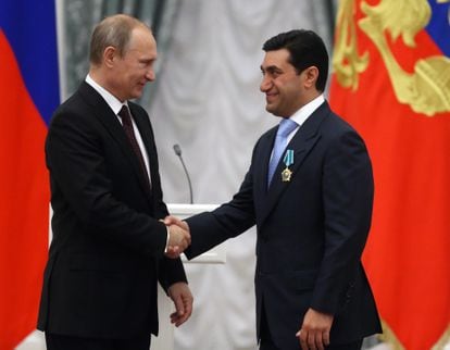 Russian President Vladimir Putin shakes hands with Russian oligarch God Nisanov on July 31, 2014 in Moscow.