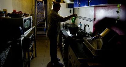 A woman works in her kitchen despite water and power cuts.