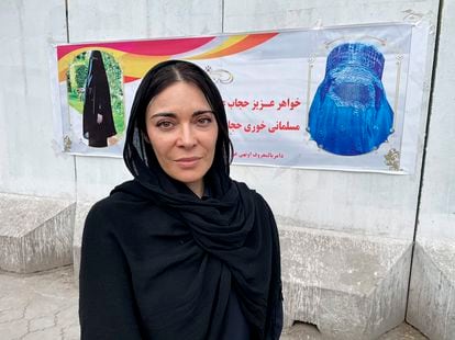 Ramita Navai, in Kabul, Afghanistan. She is pictured in front of a poster that indicates how to correctly wear a burqa.
