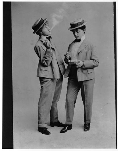 An early-20th century advertisement that shows two women dressed as men having a smoke.