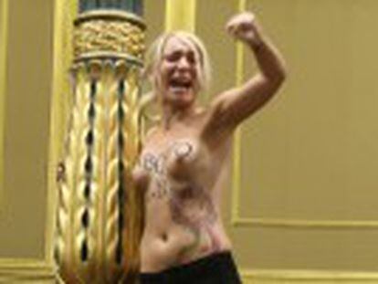 Three bare-chested Femen protestors shout slogans from spectators  gallery as justice minister speaks