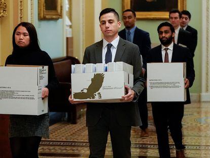 Staffers carry boxes of documents to Senate Minority Leader Chuck Schumer's office on the first day of the impeachment trial of Donald Trump, in a file photo from January 21, 2020.