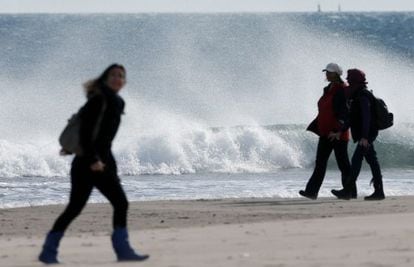 People watch the high tide caused by powerful winds coming in at the Malvarrosa beach in Valencia on Sunday.
