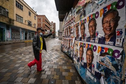 A man makes a gesture of support in front of posters of the candidate Gustavo Petro in the streets of Bogotá.