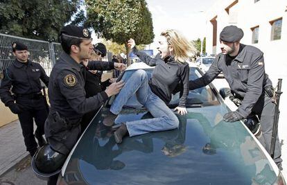 Isabel Monr&oacute;s jumps on a Civil Guard vehicle as she tries to prevent her former husband from leaving with her children.