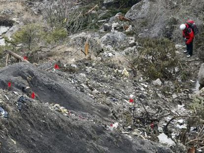 Members of the recovery team walk among debris from the Germanwings plane at the crash site.
