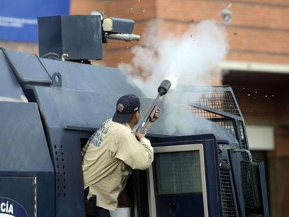 A law enforcement officer fires tear gas during a protest in Caracas.
