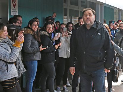Students look on as Oriol Junqueras (r) arrives at Vic University.
