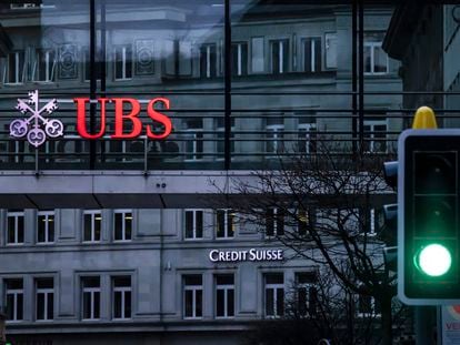 A traffic light signals green in front of the logos of the Swiss banks Credit Suisse and UBS in Zurich, Switzerland, on March 19, 2023.