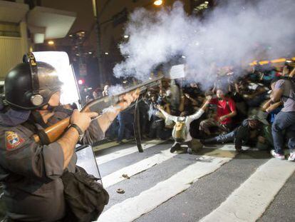 A police officer disperses a crowd of demonstrators in São Paulo.