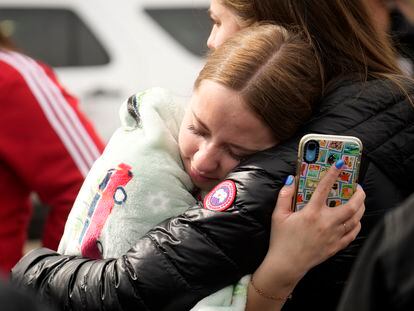 Two women hug when reunited following a shooting at East High School, on March 22, 2023, in Denver.