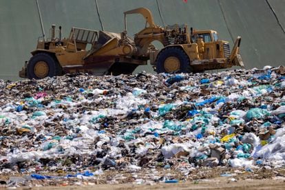 Workers use heavy machinery to move trash and waste at the Frank R. Bowerman landfill on Irvine, California, June 15, 2021.