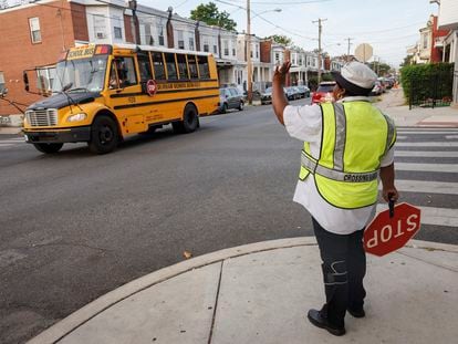 Crossing guard Pamela Lane waves a school bus passing her intersection, Master and N. 57th Street as she crosses students going to Bluford Elementary School, Tuesday, Sept. 5, 2023, in Philadelphia