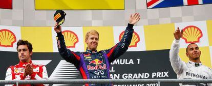 First-placed German driver Sebastian Vettel of Red Bull Racing celebrates on the podium together with second-placed Fernando Alonso (l) and Lewis Hamilton of Mercedes.