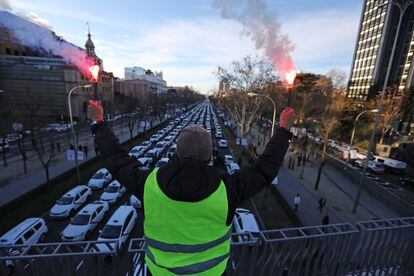 A taxi driver waves flares during the protest at Paseo de la Castellana.