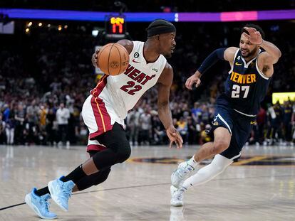 Miami Heat forward Jimmy Butler, left, moves the ball while defended by Denver Nuggets guard Jamal Murray, right, during the first half of Game 2 of basketball's NBA Finals, on June 4, 2023, in Denver.
