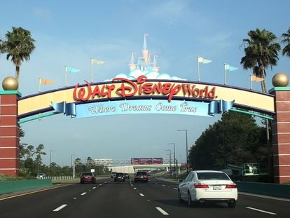 In this file photo taken on July 11, 2020, visitors drive past a sign welcoming them to Walt Disney World on the first day of reopening of the iconic Magic Kingdom theme park in Orlando, Florida.