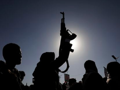 A man holds a gun during a protest against the recently announced operation to safeguard trade and protect ships in the Red Sea, in Sana'a, Yemen.