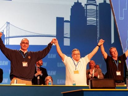 UAW President Shawn Fain raises arms with members of the International Executive Board during their 2023 Special Elections Collective Bargaining Convention in Detroit, Michigan, U.S., March 27, 2023.