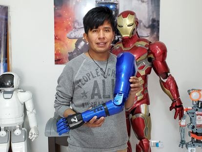 Roly Mamani holds one of his robotic creations in his workshop in La Paz,
