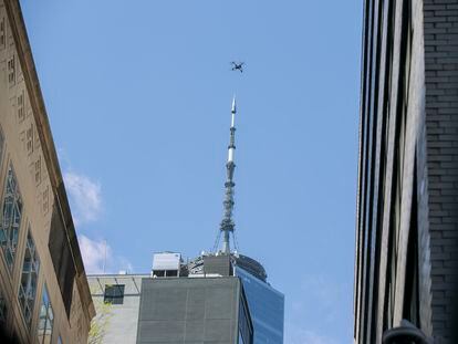An NYPD or FDNY drone flies over the site of a partially collapsed parking garage as One World Trade Center is visible in the background in New York City, April 19, 2023.