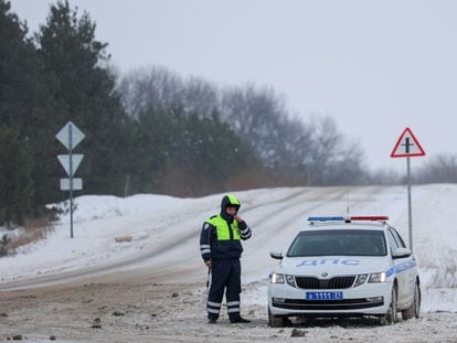 A police patrol guards the road leading to the site where a military plane was shot down on Wednesday in Russia's Belgorod region.