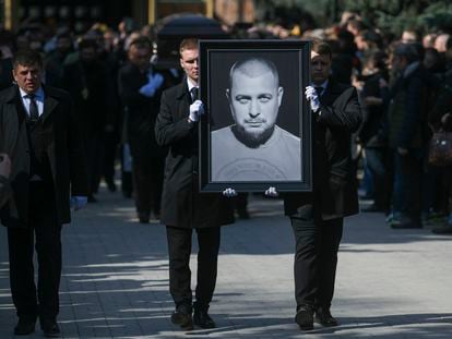 Cemetery workers carry a portrait of slain Russian military blogger Vladlen Tatarsky, during a funeral ceremony on April 8, 2023.