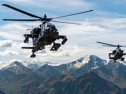 AH-64D Apache Longbow attack helicopters fly over a mountain range near Fort Wainwright, Alaska, on June 3, 2019.