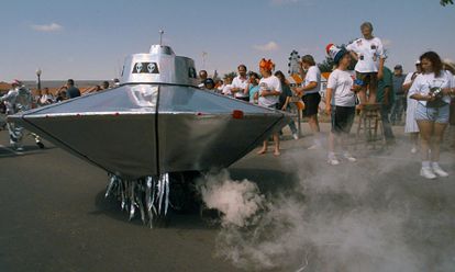 A bicycle-powered flying saucer sputters by the crowd gathered on Main Street Saturday, July 5, 1997, in Roswell, N.M