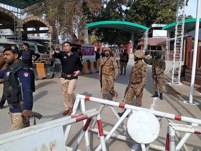 Army soldiers and police officers clear the way for ambulances rushing toward a bomb explosion site, at the main entry gate of police offices, in Peshawar, Pakistan, Monday, Jan. 30, 2023.