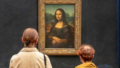 Two people look at Leonardo Da Vinci's 'Mona Lisa' in the Louvre gallery in Paris, France.