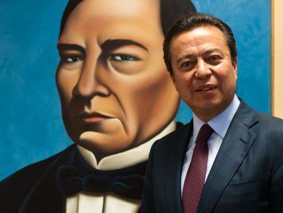 César Camacho Quiroz, stands before a portrait of Benito Juárez.