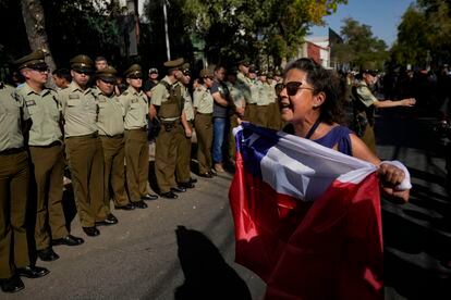 A woman holds a Chilean flag during a funeral procession for a murdered police officer in Santiago, Chile, on April 6.