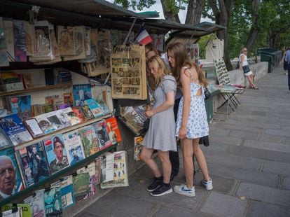 Tourists browse a bookstand along the Seine River in Paris.