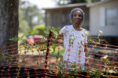 Jonesville Historic Gullah Neighborhood resident Josephine Wright stands between her home and an orange safety fence that boarders the 29-acre construction site, Tuesday, July 18, 2023, in Hilton Head Island, S.C. A Georgia-based developer's planned 147-unit short-term rental complex that broke ground last summer. (AP Photo/Stephen B. Morton)