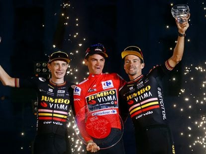 Team Jumbo–Visma's Sepp Kuss celebrates on the podium after winning Vuelta a Espana alongside second place Team Jumbo–Visma's Jonas Vingegaard and third place Team Jumbo–Visma's Primoz Roglic .