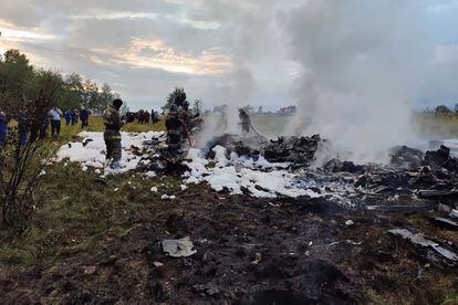 A handout photograph taken and released by Russian Investigative Committee on Aug. 23, 2023, shows rescuers working at the site of a plane crash near the village of Kuzhenkino, Tver region.