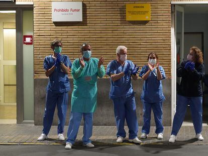 Health workers at a hospital in Seville applaud outside the emergency ward.