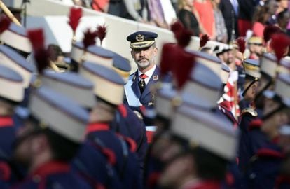 King Felipe VI watches on as troops file past.