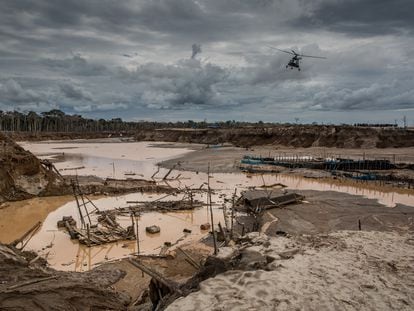 A police helicopter flies over an illegal mining area in the Madre de Dios region of Peru