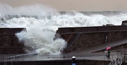 A man looks as a wave breaks through a seawall in Bermeo, Vizcaya province, on Sunday. 