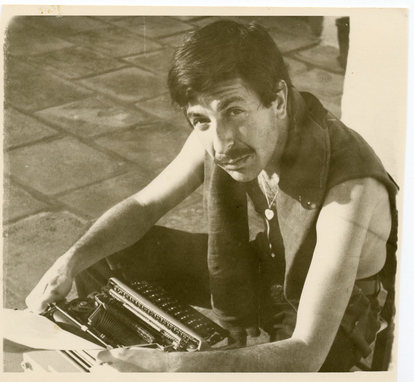 Cohen on Hydra (with typewriter), 1960. Photographer unknown. © Leonard Cohen Family Trust
