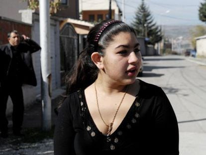 Leonarda Dibrani, the 15-year-old schoolgirl whose deportation from France sparked a huge outcry, speaks to the media as her father Resat talks on his cellphone outside their temporary home in Mitrovica. 